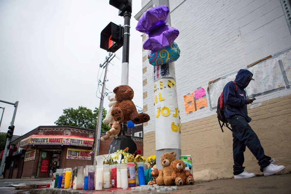 A memorial has popped up for Jonathan Dos Santos on the corner of Washington and Fuller streets in Dorchester, where he was shot and killed last week. (Jesse Costa/WBUR)