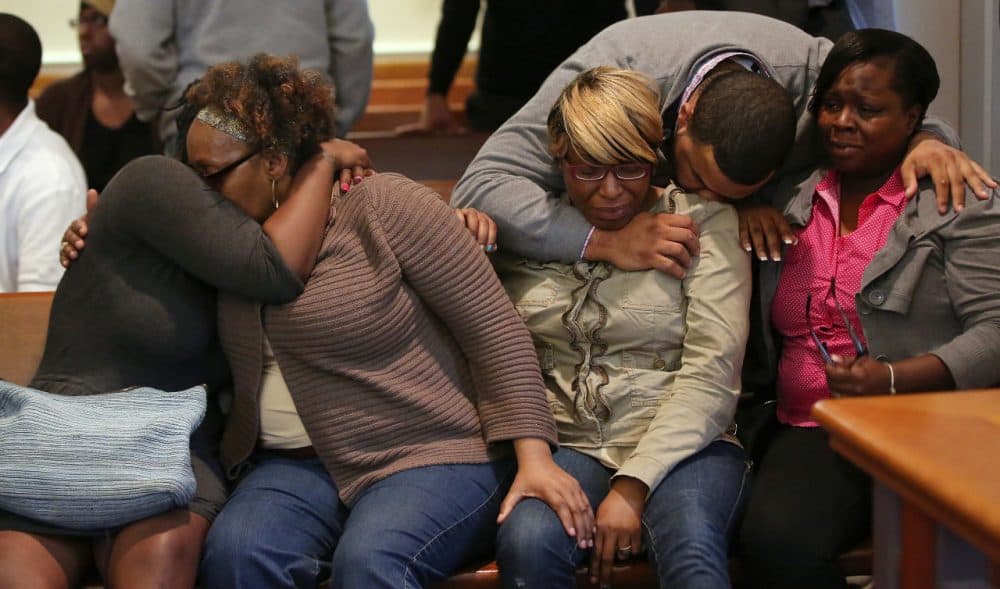 The family and supporters of Dushawn Taylor-Gennis, including his mother Genneane Gennis, seated second from right, react at the end of the session in Dorchester Municipal Court in Boston, Monday. Taylor-Gennis and Raeshawn Moody have been charged with gunning down Jonathan Dos Santos out riding his bike and have been held without bail. (Pat Greenhouse/The Boston Globe via AP, Pool)