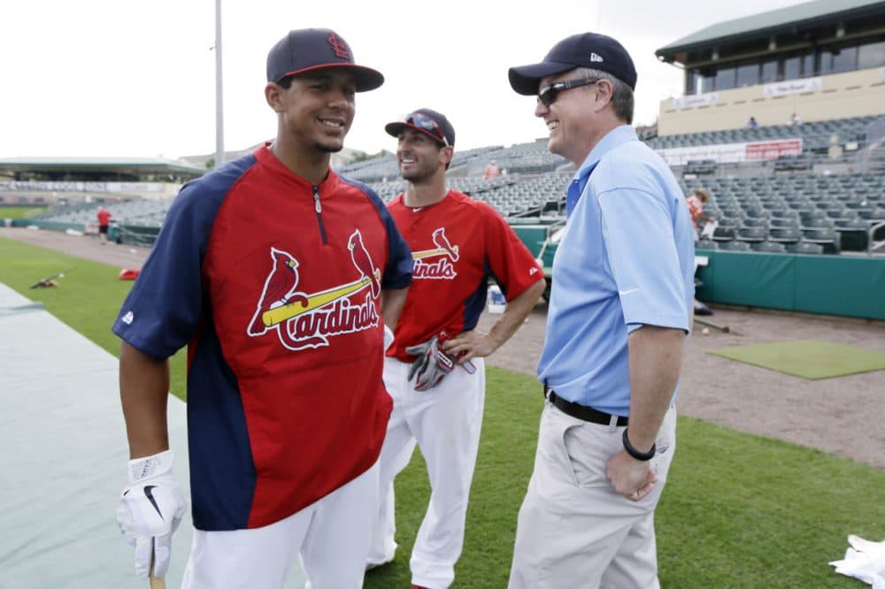 In this Feb. 25, 2013 photo, Houston Astros general manager Jeff Luhnow, right, talks to St. Louis Cardinals center fielder Jon Jay, left, and second baseman Daniel Descalso before an exhibition spring training baseball game in Jupiter, Fla. Major League Baseball says it is cooperating with a federal investigation into an illegal breach of the Astros' internal operations database, amid a report that the Cardinals were responsible for the hack. (Julio Cortez/AP)