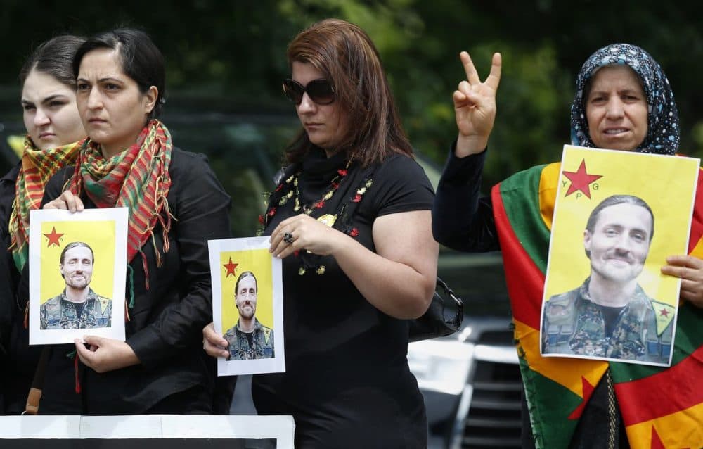 People from the New England Kurdish Association hold pictures of Keith Broomfield outside the Grace Baptist Church in Hudson, Mass., following a funeral service for Broomfield, Wednesday, who was killed in Syria while fighting the self-described Islamic State. (Michael Dwyer/AP)