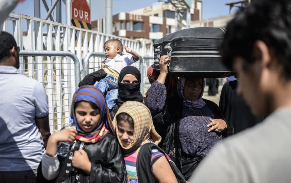 Syrian refugees wait prior to go back to the northern Syrian town of Tal Abyad at the Turkish border post of Akcakale, the province of Sanliurfa, on June 17, 2015. The first Syrian refugees returned to the border town of Tal Abyad from Turkey after it was liberated from the Islamic State group, an AFP journalist reported. Kurdish forces took the strategic town on Tuesday after several days of intense fighting, which sparked an exodus of more than 23,000 refugees into neighbouring Turkey. (Bulent Kilic/AFP/Getty Images)