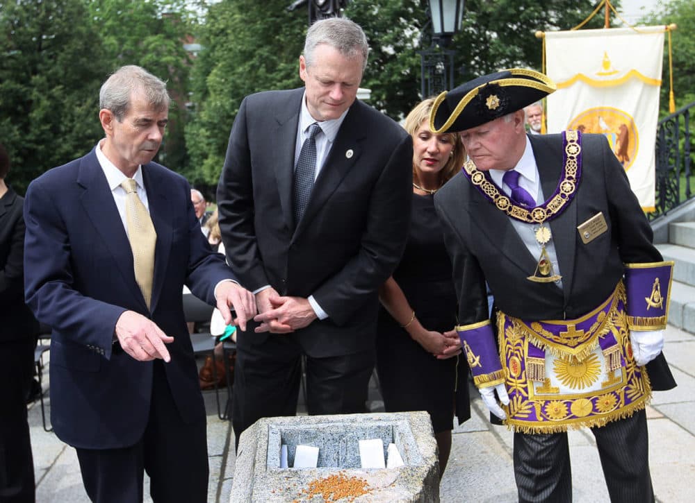 From left, Secretary of State William Galvin, Gov. Charlie Baker, Lt. Gov. Karyn Polito and Grand Master of Masons Harvey Waugh look at the opening in the cornerstone for the time capsule. (Joanne Rathe/Boston Globe/Pool)