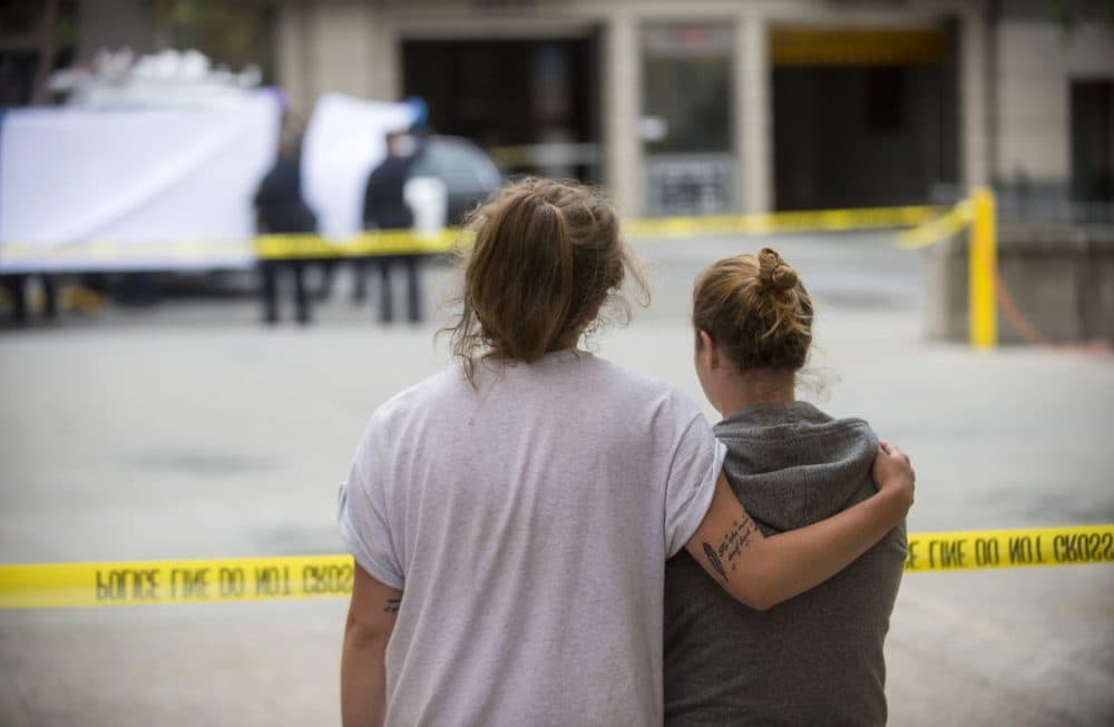 Two women embrace while watching sheriff's deputies move the body of a person who died when a fourth floor balcony collapsed in Berkeley, Calif. on Tuesday, June 16, 2015. (Noah Berger/AP)
