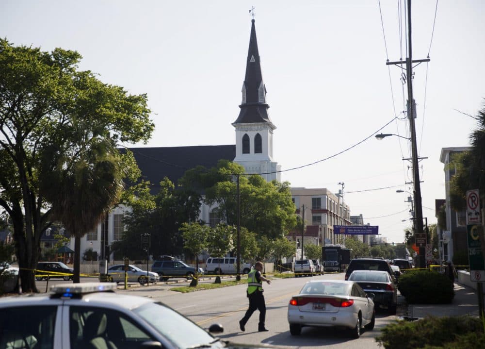 The steeple of Emanuel AME Church rises above the street as a police officer tells a car to move as the area is closed off following Wednesday's shooting, Thursday, June 18, 2015 in Charleston, S.C. (David Goldman/AP)