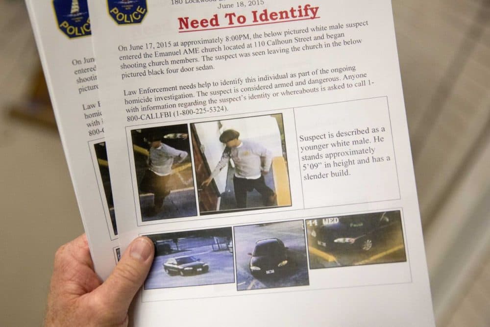 Charleston Emergency Management Director Mark Wilbert holds a flier distributed to media, Thursday, June 18, 2015, with surveillance footage of a suspect wanted in the connection of a shooting Wednesday at Emanuel AME Church during a news conference, in Charleston, S.C. (David Goldman/AP)