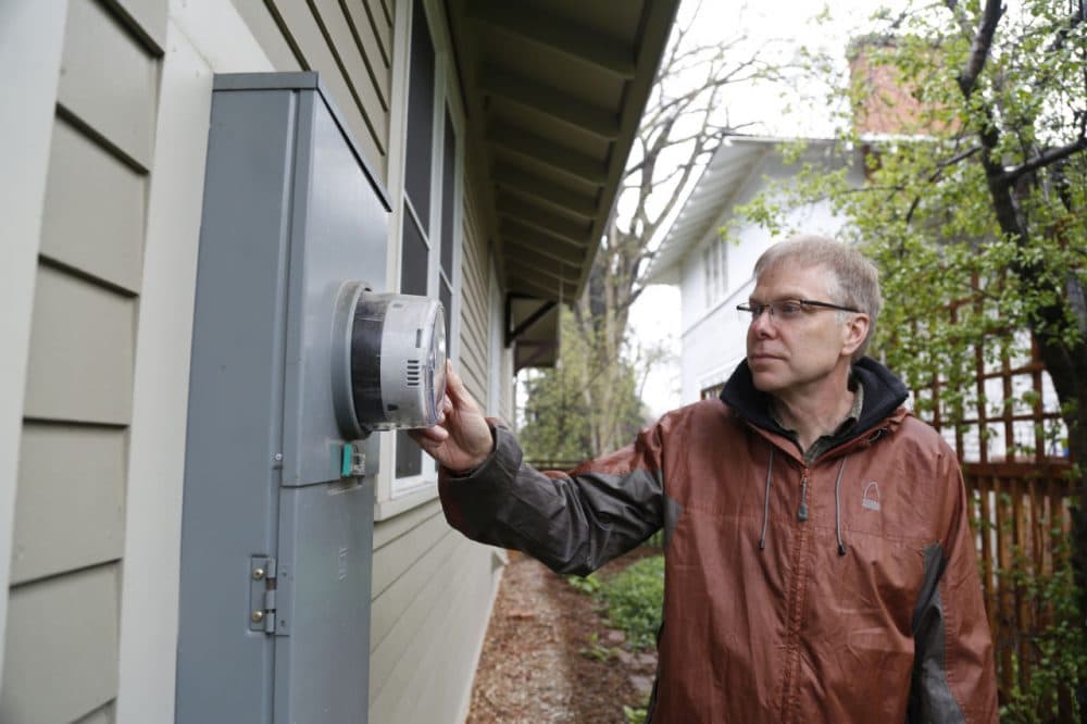 John Phelan with Fort Collins Utilities inspects the smart meter at his home. (Dan Boyce)