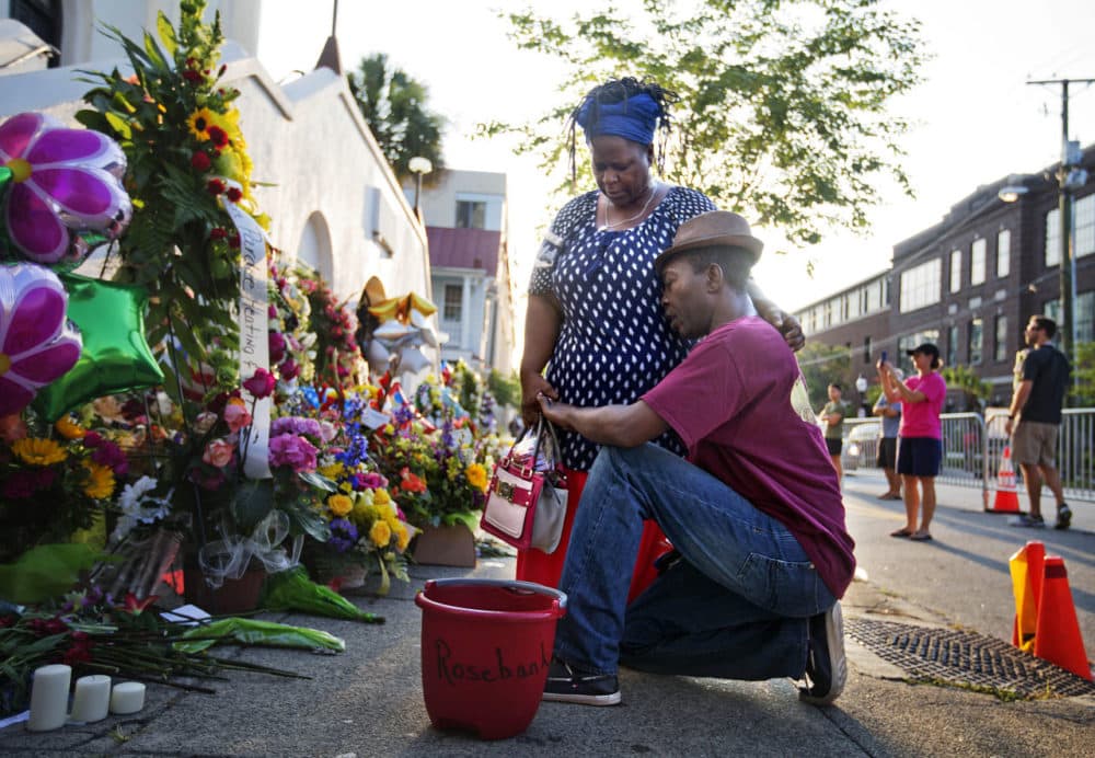 Allen Sanders, right, kneels next to his wife Georgette, both of McClellanville, S.C., as they pray at a sidewalk memorial in memory of the shooting victims in front of Emanuel AME Church Saturday. (David Goldman/AP)
