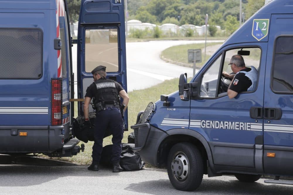 Riot police officers block the area where an attack took place, Friday, June 26, 2015 in Saint-Quentin-Fallavier, southeast of Lyon, France. A man with suspected ties to French Islamic radicals rammed a car Friday into an American gas factory in southeastern France, triggering an explosion that injured two people, officials said. The severed head of a local businessman was left hanging at the factory's entrance, along with banners with Arabic inscriptions, they said. (Laurent Cipriani/AP)