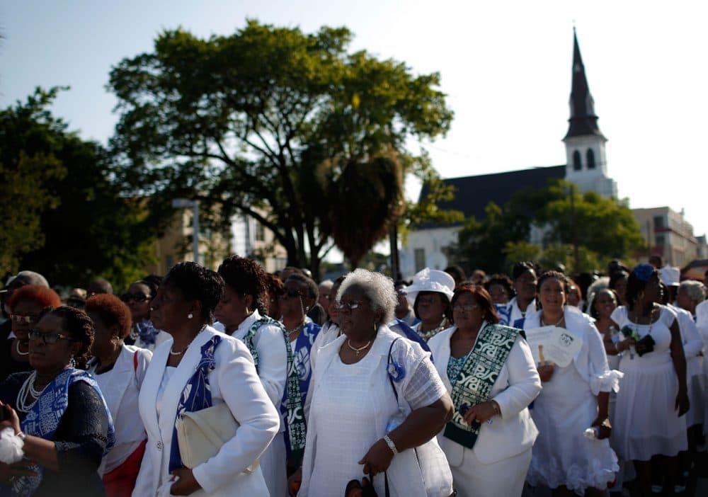 Mother Emanuel African Methodist Episcopal church is seen in the background as women dressed in white wait to enter the funeral service where U.S. President Barack Obama will deliver the eulogy for South Carolina State senator and Rev. Clementa Pinckney who was killed along with eight others in a mass shooting June 26, 2015 in Charleston, South Carolina. (Win McNamee/Getty Images)