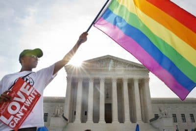 Carlos McKnight of Washington, waves a flag in support of gay marriage outside of the Supreme Court in Washington, Friday June 26, 2015. (Jacquelyn Martin/AP)