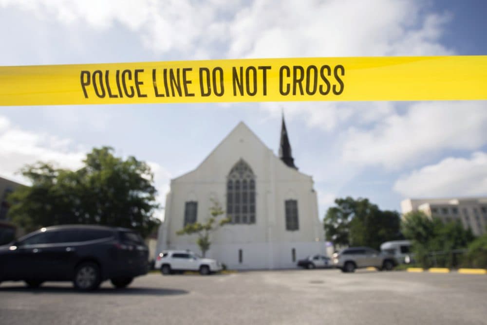 Police tape surrounds the parking lot behind the AME Emanuel Church Friday as FBI forensic experts work the crime scene where nine people were allegedly shot by Dylann Storm Roof on Wednesday in Charleston, S.C. (Stephen B. Morton/AP)