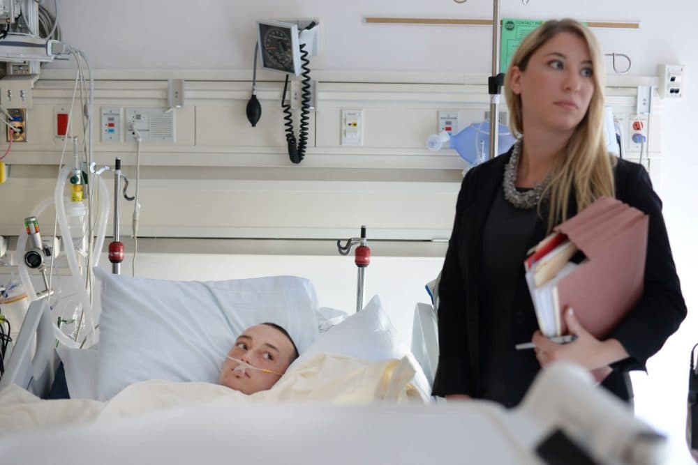 Brock Fleming, 21, listens as he is arraigned in his hospital bed at North Shore Medical Center as his attorney Christina Liwski looks on in Salem, Mass., Wednesday, June 10, 2015. (Paul Bilodeau/The Salem News via AP)