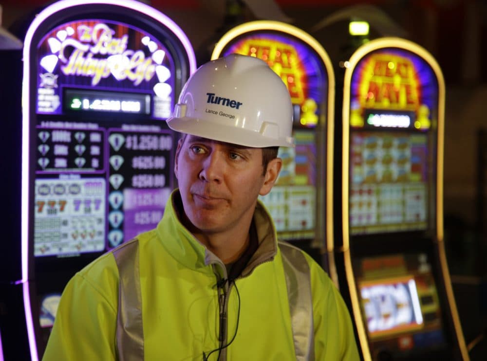 Lance George, Plainridge Park Casino's general manager, stands in front of slot machines on the nearly-completed gambling floor Monday, May 11, 2015, in Plainville, Mass. Penn National Gaming has invested about $250 million to transform the harness racing and simulcast betting facility into a regional destination scheduled to have is grand opening next month. ( (AP Photo/Stephan Savoia)