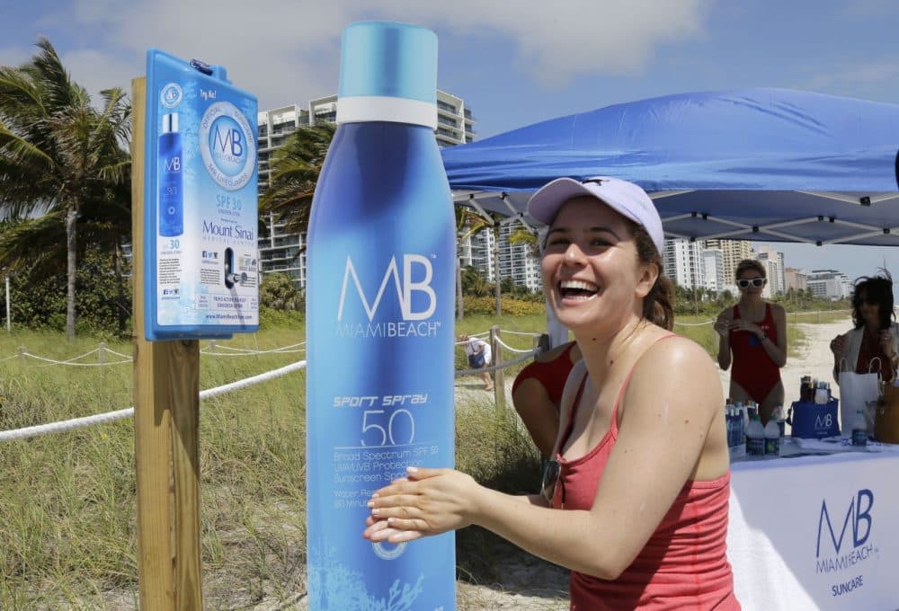 In March, Miami installed several sunscreen dispensers that are similar to those that are coming to Boston this summer. Pictured here, Rachel Gerber, of New York City, uses a sunscreen dispenser in Miami Beach, Florida. (Alan Diaz/AP)