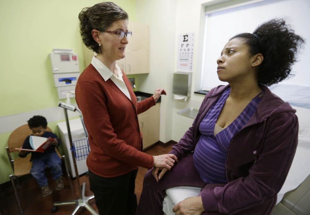 Certified nurse midwife Danielle Kraessig meets with patient Yakini Branch at the PCC South Family Health Center in 2013 in Berwyn, Ill. The clinic received a permit to operate the first birth center in Illinois. (M. Spencer Green/AP)