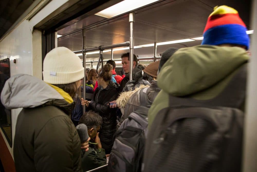 Passengers squeeze aboard a Red Line train at the Porter Square MBTA station. (Robin Lubbock/WBUR)