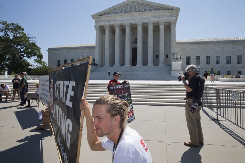People in support of abolishing the death penalty protest outside of the Supreme Court in Washington Monday. (Jacquelyn Martin/AP)