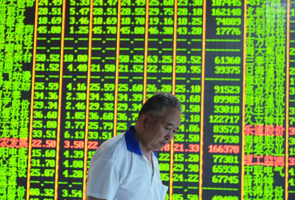 An investor walks past a share prices board at a security firm in Hangzhou, eastern China's Zhejiang province on June 30, 2015.  (STR/AFP/Getty Images)
