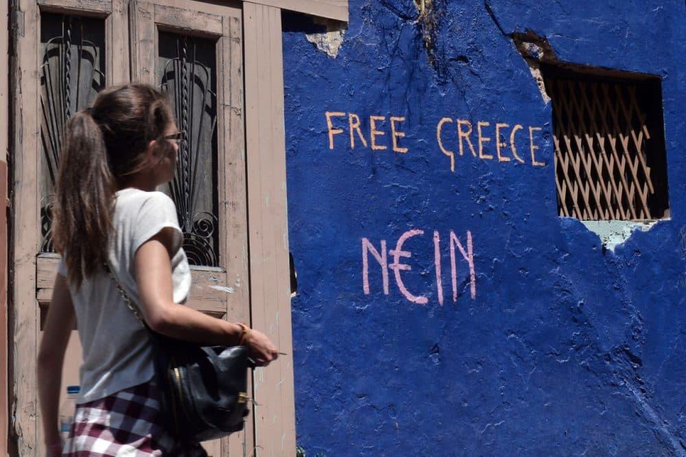 A woman walks past a slogan written on a wall in Athens on July 7, 2015. Eurozone leaders will hold an emergency summit in Brussels on July 7 to discuss the fallout from Greek voters' defiant 'No' to further austerity measures, with the country's Prime Minister Alexis Tsipras set to unveil new proposals for talks. (Louisa Gouliamaki/AFP/Getty Images)