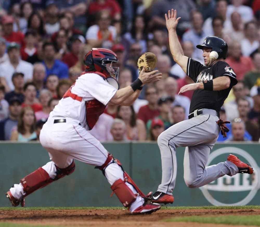Miami Marlins' Cole Gillespie beats the throw, and tag by Boston Red Sox catcher Ryan Hanigan, to score on a single by Christian Yelich during the third inning of a game in Boston, Tuesday July 7, 2015. (Charles Krupa/AP)
