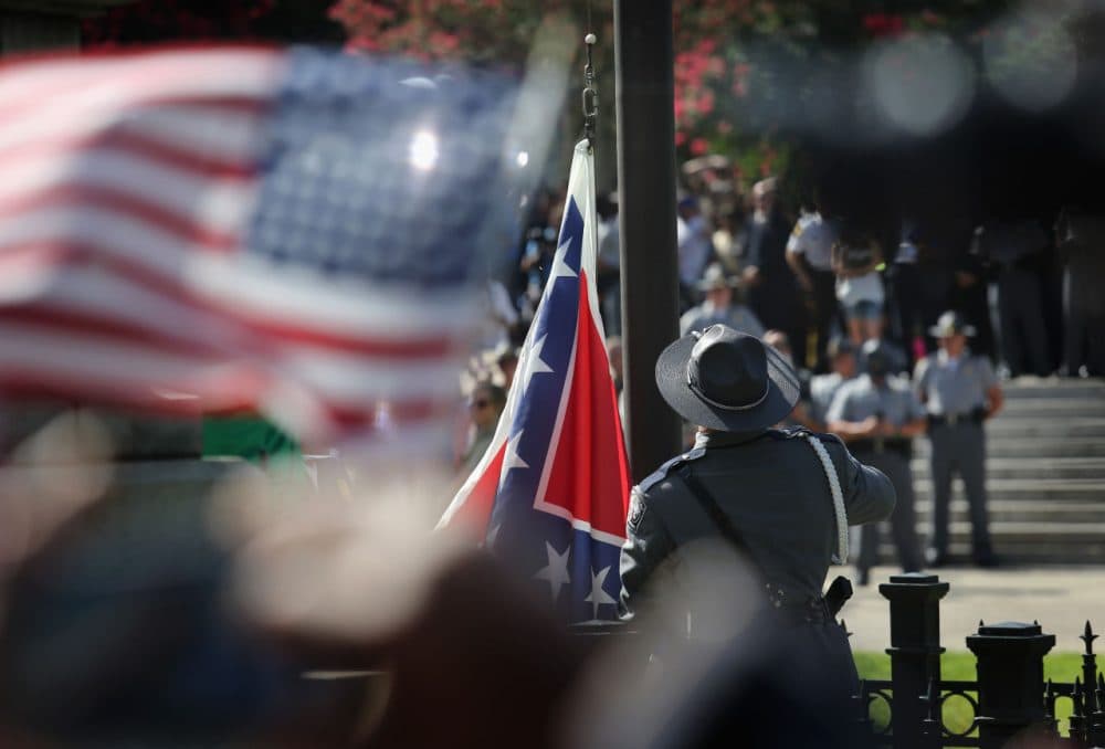 A South Carolina state police honor guard lowers the Confederate flag from the Statehouse grounds on July 10, 2015 in Columbia, South Carolina. Republican Governor Nikki Haley presided over the event after signing the historic legislation to remove the flag the day before. (John Moore/Getty Images)