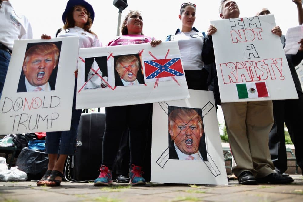 Protesters holds signs with the image of billionaire Republican presidential candidate Donald Trump as they demonstrate against the Trump International Hotel, which is currently under construction on Pennsylvania avenue between the U.S. Capitol and the White House, July 9, 2015 in Washington, D.C. Latino and Hispanic people were enraged when Trump disparaged immigrants and particularly Mexican-Americans while announcing his run for the presidency. Famous chef Jose Andres announced Wednesday that he will not longer open a Spanish restaurant in the hotel because of Trump's racist remarks. (Chip Somodevilla/Getty Images)