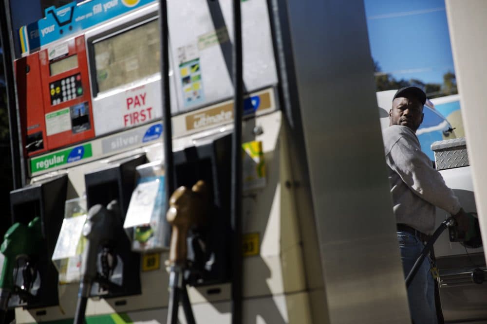 Motorist Jerry Reed watches the pump display while filling up his tank at a gas station, Thursday, Oct. 30, 2014, in Atlanta. (David Goldman/AP)