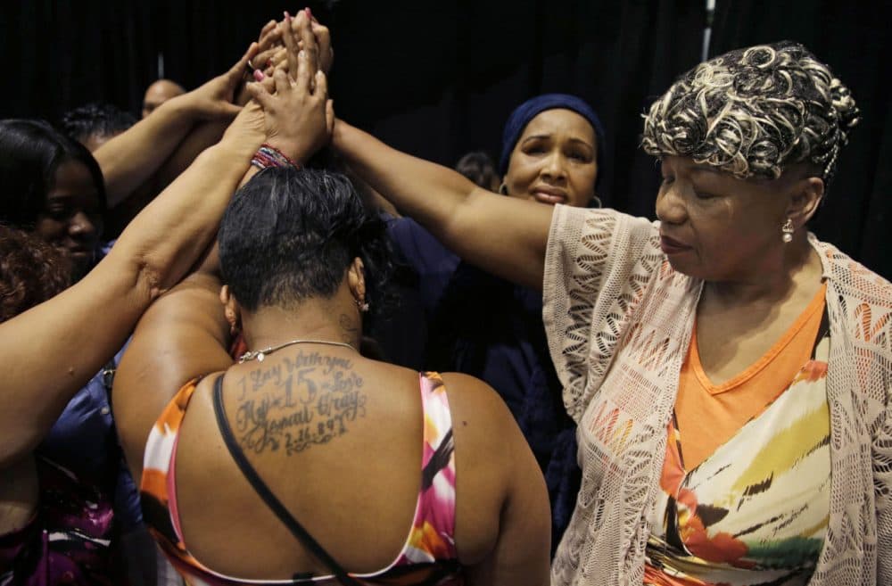 In this July 8, 2015 photo, Gwen Carr, mother of Eric Garner, right, joins women whose families members were killed by police officers after New York Gov. Andrew Cuomo signed an executive order that puts the office of the state attorney general in charge of investigating killings by police. New York City reached a settlement Monday, July 13 with the family of Garner for about $5.9 million, almost a year after the 43-year-old died in police custody. (Seth Wenig/AP)