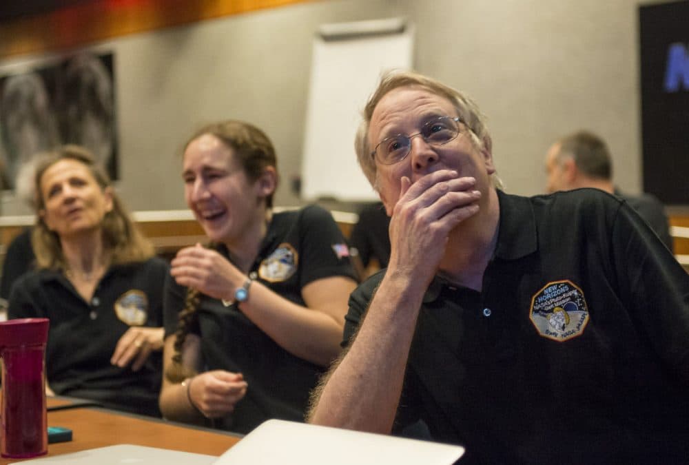 Members of the New Horizons science team, including MIT Professor Richard Binzel, graduate student Alissa Earle (MIT), and Cristina Dalle Ore (SETI Institute), react to seeing the spacecraft's last and sharpest image of Pluto before closest approach later in the day. (Courtesy Bill Ingalls/NASA)