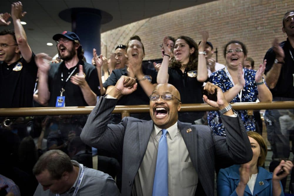 NASA and project staff react with others as telemetry is received from the New Horizons probe at the Johns Hopkins University Applied Physics Laboratory in Laurel, Maryland on July 14, 2015. (Brendan Smialowski/AFP/Getty Images)
