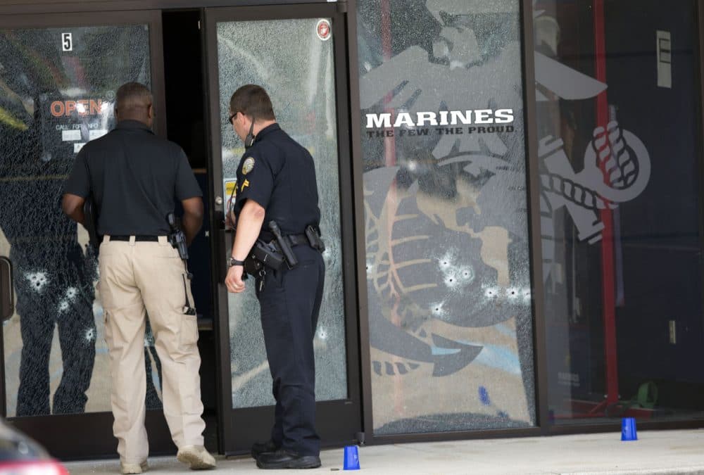 Police officers enter the Armed Forces Career Center through a bullet-riddled door after a gunman opened fire on the building Thursday, July 16, 2015, in Chattanooga, Tennessee. (John Bazemore/AP)