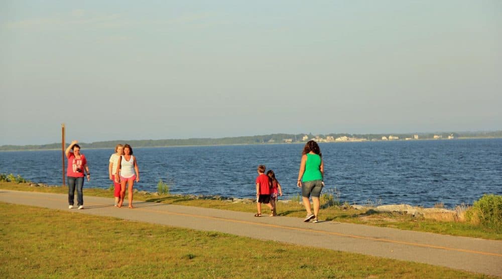 People walk along Fort Taber Park in New Bedford. The city was the proposed site to host Olympic sailing, had Boston won its bid to host the 2024 Games. (Simon Rios/WBUR)