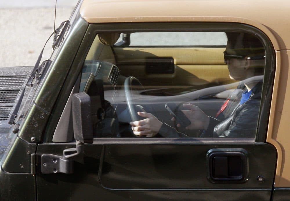 In this file photo, a driver uses their cellphone in Los Angeles in 2011. (Damian Dovarganes/AP)
