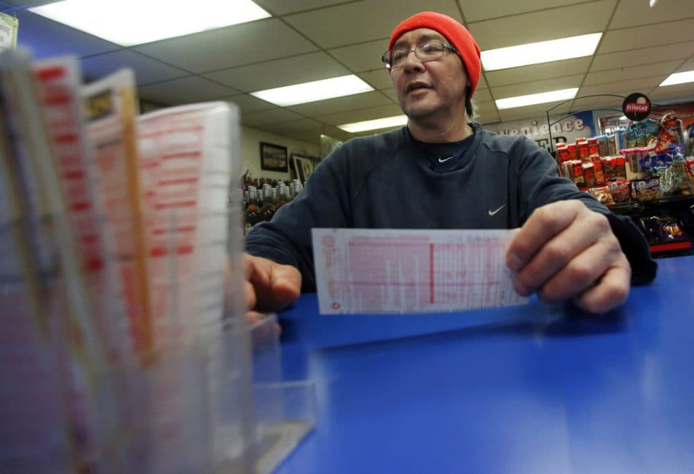 Robert Allen buys a Powerball ticket at a North Andover convenience store on Feb. 19, 2014. (Elise Amendola/AP)