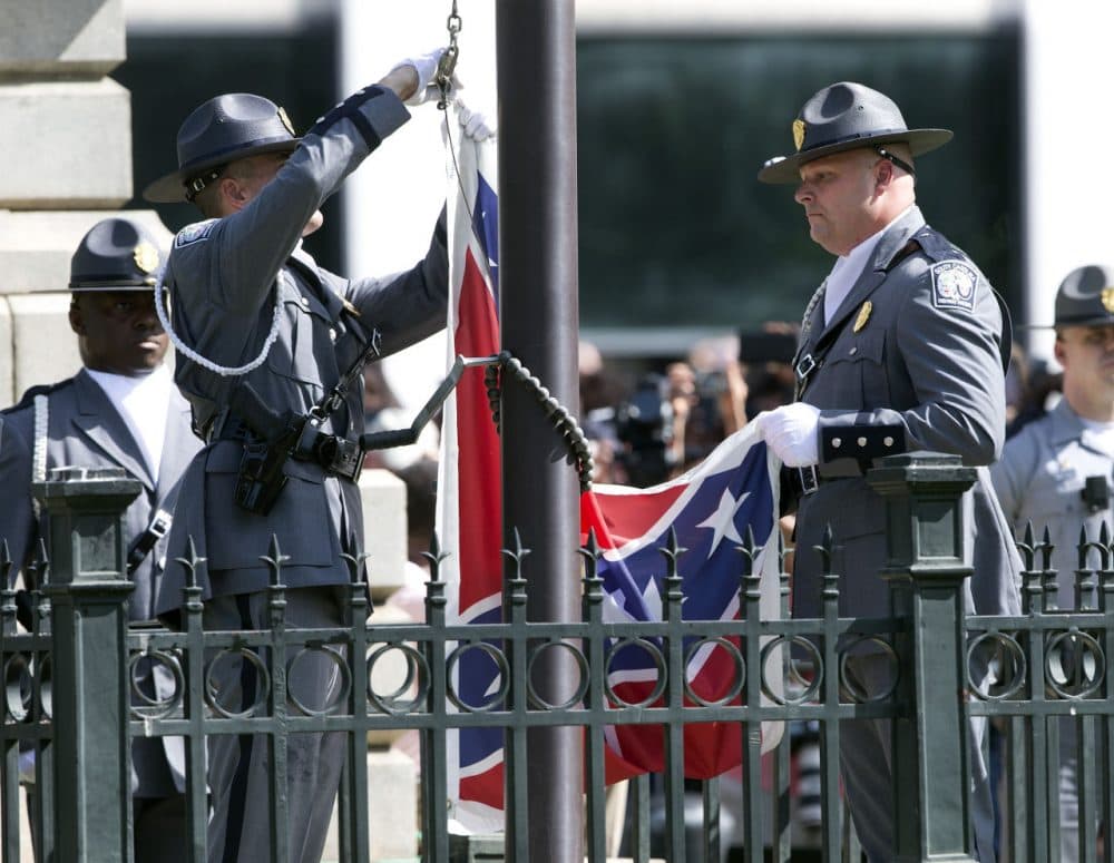 An honor guard from the South Carolina Highway patrol lowers the Confederate battle flag as it is removed from the Capitol grounds Friday in Columbia, South Carolina. (John Bazemore/AP)