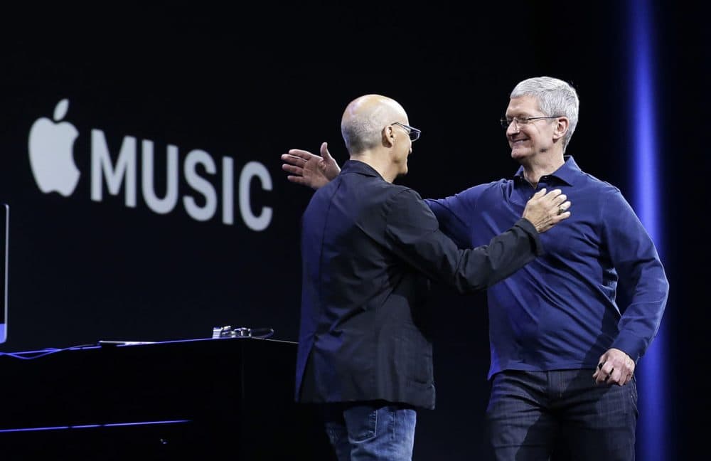 Apple CEO Tim Cook, right, hugs Jimmy Iovine at the announcement of Apple Music in June.  (Jeff Chiu/AP)