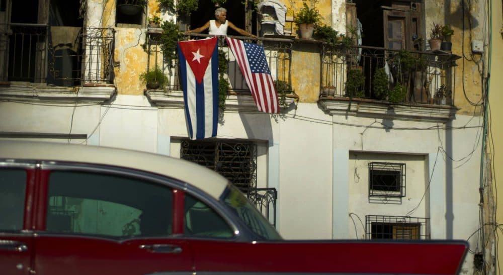 Judy Bolton-Fasman: &quot;My mother wants the doors to open to the Cuba she once knew, not the country she sees as grotesquely frozen in time.&quot; In this picture, Javier Yanez looks out from his balcony, where he hung American and Cuban national flags to celebrate the restored full diplomatic relations between Cuba and the United States, in Old Havana, Monday, July 20, 2015, the day the U.S. restored diplomatic relations with the island nation. (Ramon Espinosa/AP)