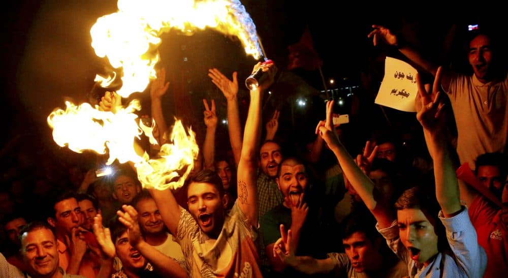 Iranians celebrate following a landmark nuclear deal in Tehran, Iran, Tuesday, July 14, 2015. After long, fractious negotiations, world powers and Iran struck an historic deal Tuesday to curb Iran's nuclear program in exchange for billions of dollars in relief from international sanctions, an agreement aimed at averting the threat of a nuclear-armed Iran and another U.S. military intervention in the Middle East. (Ebrahim Noroozi/AP)