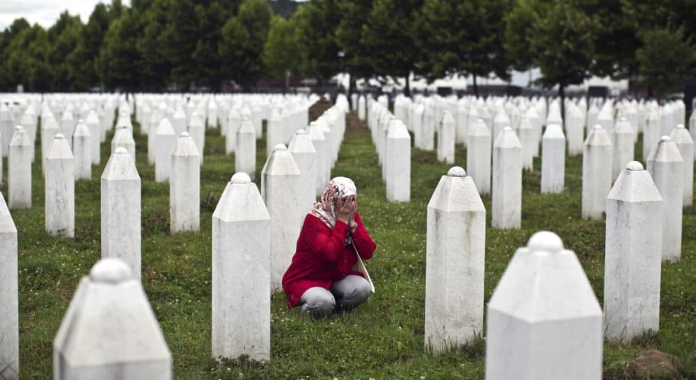 A woman prays next to a grave of her relative at the Potocari memorial complex, in Potocari, close to Srebrenica, 150 kilometers northeast of Sarajevo, Thursday, July 9, 2015. The 20th anniversary of the Srebrenica massacre, the worst crime in Europe after the Nazi era, will be marked on Saturday, July 11, 2015. (Marko Drobnjakovic/AP)