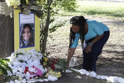 Jeanette Williams places a bouquet of roses at a memorial for Sandra Bland near Prairie View A&amp;M University, Tuesday, July 21, 2015, in Prairie View, Texas. A newly released dashcam video documents how a routine traffic stop escalated into a shouting confrontation between a Texas state trooper and Bland, which led to her arrest. (AP Photo/Pat Sullivan)