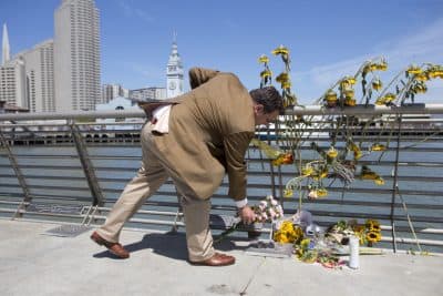 A mourner lays down flowers following a vigil for Kathryn Steinle, Monday, July 6, 2015, on Pier 14 in San Francisco. Steinle was gunned down while out for an evening stroll at Pier 14 with her father and a family friend on Wednesday, July 1. (AP)