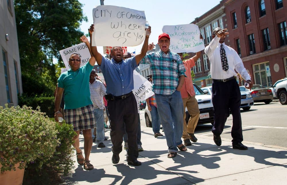 Cambridge taxi drivers protest on the street outside City Hall Monday morning. (Hadley Green for WBUR)