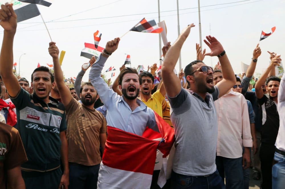 Protesters chant anti-government slogans as they wave national flags during a protest against corruption and the lack of government services and power outages in front of the provincial council building in Basra, 340 miles (550 kilometers) southeast of Baghdad, Iraq, Saturday, Aug. 1, 2015. (Nabil al-Jurani/AP Photo)