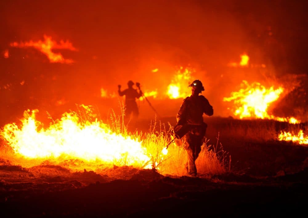 A firefighter lights a backfire as the Rocky Fire burns near Clearlake, Calif., on Monday, Aug. 3, 2015. The fire has charred more than 60,000 acres and destroyed at least 24 residences. (Josh Edelson/AP)