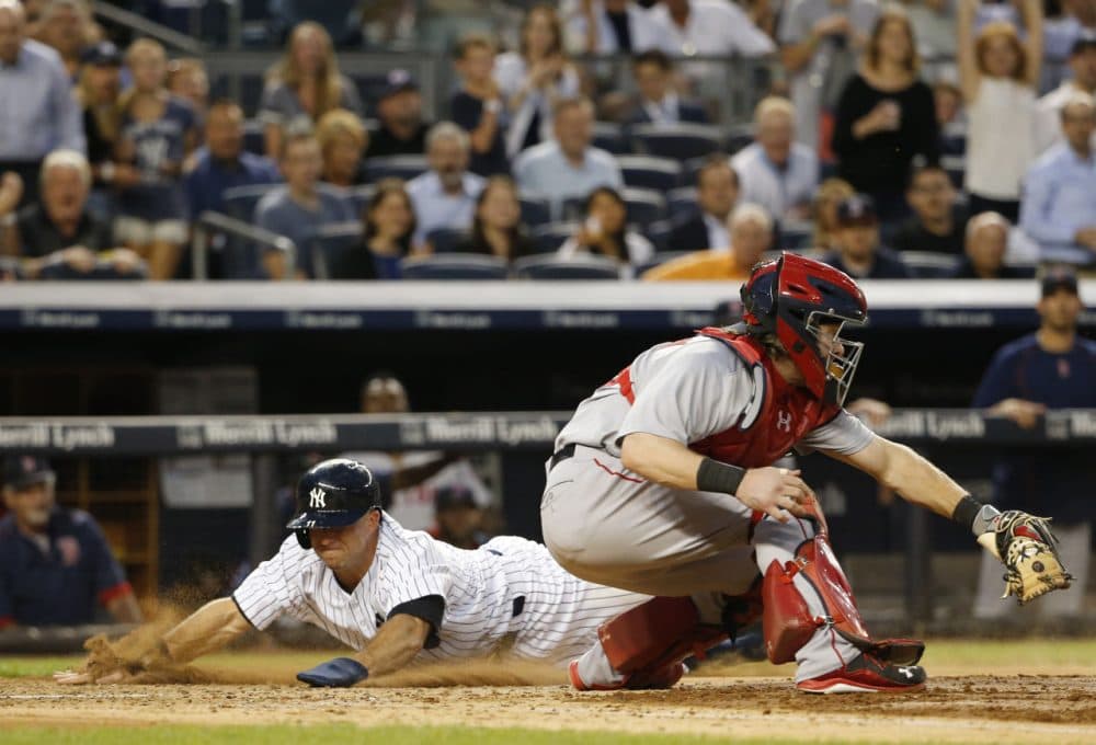Yankees' Brett Gardner, left, slides in behind Red Sox catcher Ryan Hanigan on Alex Rodriguez's third-inning RBI-double at Yankee Stadium, Thursday, Aug. 6, 2015. (Kathy Willens/AP)