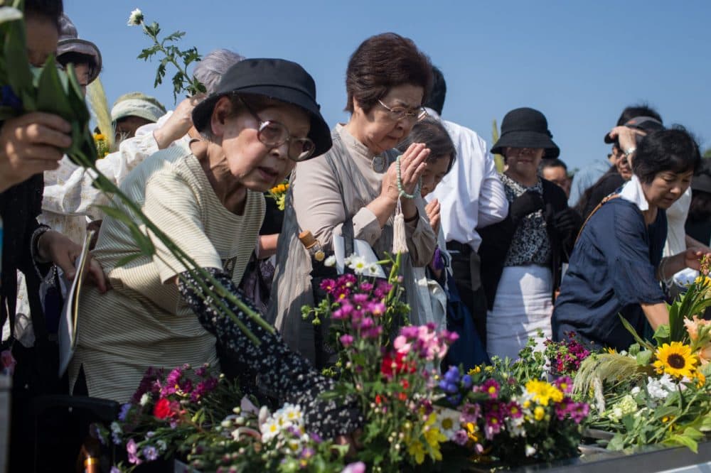 People pray at the Hiroshima Peace Memorial after the 70th anniversary ceremony of the atomic bombing of Hiroshima at the Hiroshima Peace Memorial Park on August 6. Japan marks the 70th anniversary of the first atomic bomb that was dropped by the United States on Hiroshima on August 6, 1945. The bomb instantly killed an estimated 70,000 people and thousands more in coming years from radiation effects. Three days later the United States dropped a second atomic bomb on Nagasaki which ended World War II. (Chris McGrath/Getty Images)