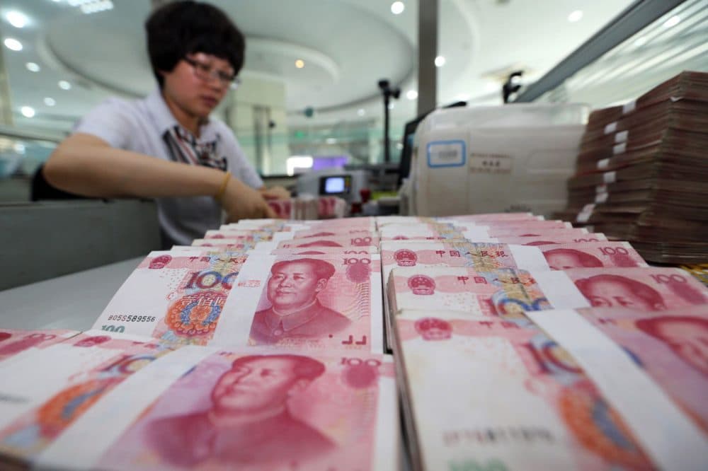 A teller counts yuan banknotes in a bank in Lianyungang, east China's Jiangsu province on August 11, 2015. China's central bank on August 11 devalued its yuan currency by nearly two percent against the US dollar, as authorities seek to push market reforms and bolster the world's second-largest economy. (STR/Getty Images)