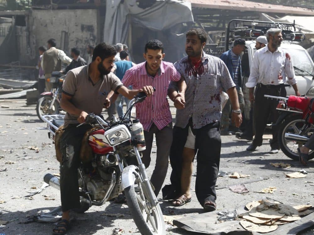 Syrian men react at the scene of reported air strikes by regime forces in the rebel-held Eastern Ghouta area near Damascus today. At least 31 civilians were killed in Syrian government air strikes near Damascus as a barrage of deadly rebel rocket fire hit the capital, a monitor said. (Sameer al-Doumy/Getty Images)