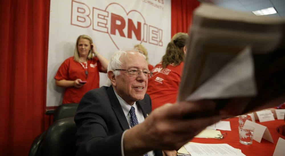 Renée Loth: Most Americans recoil from the socialist label. And yet, most of what presidential candidate Sen. Bernie Sanders touts on the campaign trail was just boiler-plate Democratic party doctrine not long ago. In this photo, Sanders hands back autographed newspapers during a visit to the National Nurses United office Monday, Aug. 10, 2015, in Oakland, Calif. (Eric Risberg/AP)