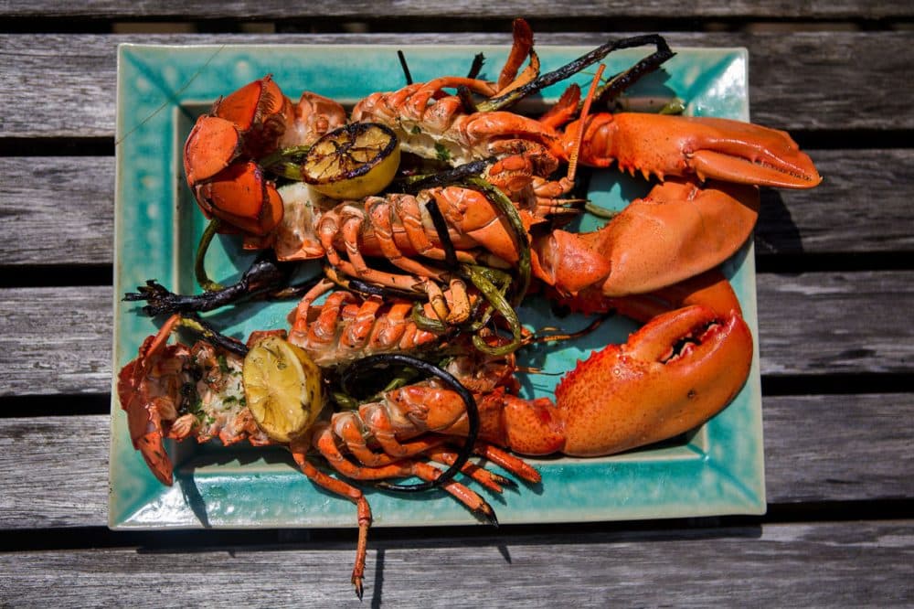 Two grilled lobsters are ready to be eaten. (Jesse Costa/WBUR)